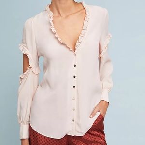 Blush blouse with shuttle ruffle detail at neckline and a cut out sleeve.